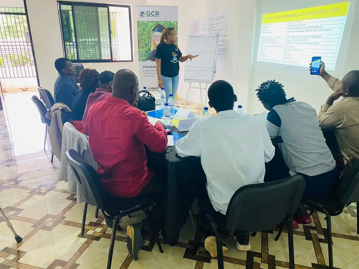 Facilitador apresenta durante o seminário, com participantes sentados às mesas, em Nhamatanda