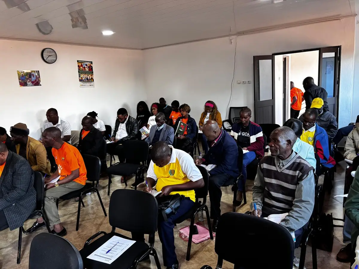 Líderes comunitários sentados numa sala de reuniões durante a sessão no escritório da GCR em Chimoio