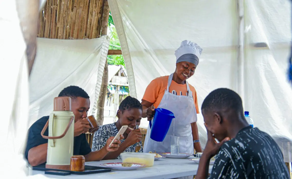 Mulher serve clientes no seu negócio de comida